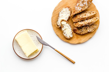 Slice of bread with butter on white background top view
