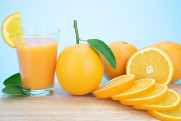 Orange juice and oranges with leaves