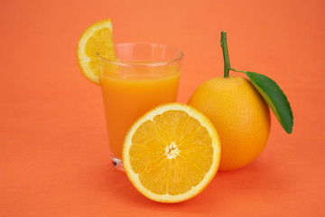 Orange juice and oranges with leaves