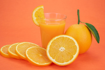 Orange juice and oranges with leaves