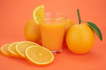Orange juice and oranges with leaves