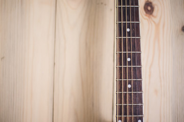 acoustic guitar neck on wooden background with strings