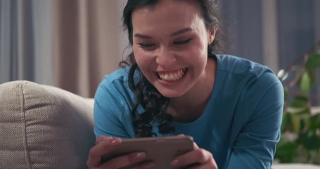 Woman having fun watching online media content on mobile phone