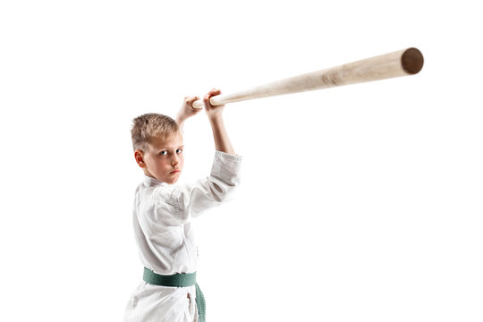 Teen boy fighting with wooden sword at Aikido training in martial arts school. Healthy lifestyle and sports concept. Fightrer in white kimono on white background. Karate man in uniform.