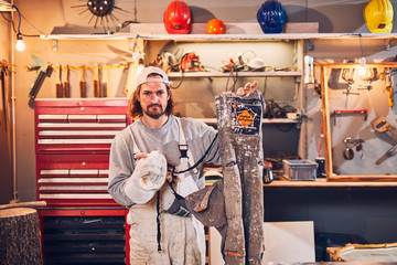 Male carpenter fixing old wood in a retro vintage workshop.