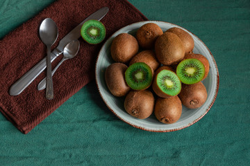 kiwi monstera green spoon plate dish table tropical fruit leave knife cutter brown napkin towel