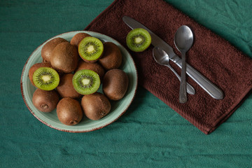 kiwi monstera green spoon plate dish table tropical fruit leave knife cutter brown napkin towel