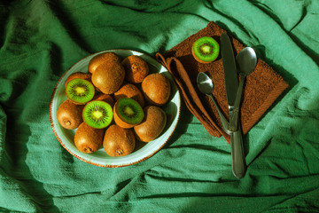 kiwi monstera green spoon plate dish table tropical fruit leave knife cutter brown napkin towel