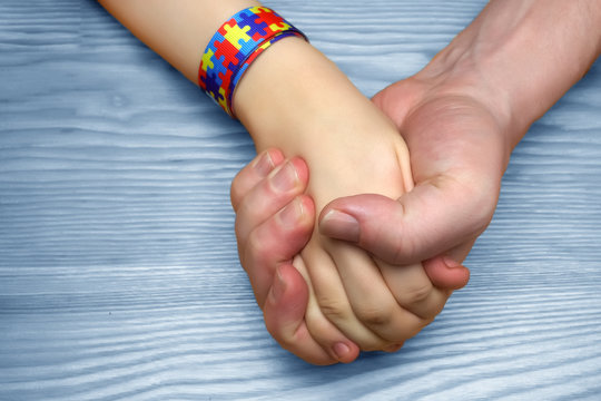 Autism Awareness Picture. Father holding hand his autistic child