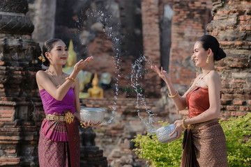 Thailand culture. Thai girls and thai women playing splashing water during with Thai Traditional costume in the temple of Ayutthaya Thailand festival Songkran festival.