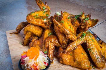 Buffalo chicken wings with  sweet chili sauce on white wooden board