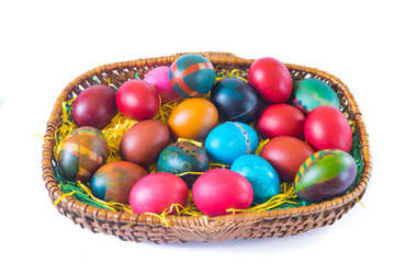 Colorful easter eggs in basket isolated on white background