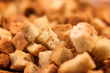 Crispy golden freshly sauteed croutons made of cubes white bread as a delicious crunchy addition to a bowl of hot winter soup. Soft focus