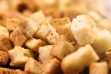 Crispy golden freshly sauteed croutons made of cubes white bread as a delicious crunchy addition to a bowl of hot winter soup. Soft focus