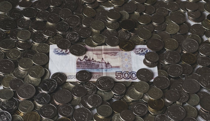 russian five hundred rubles bill on various coins. paper and metal money for background and...