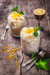 Two glasses of rice pudding on wooden rustic table. Close up