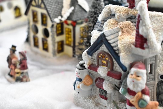 Christmas Decorating, small houses and people in the snowy street
