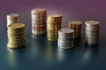 Closeup of silver and copper coins of all states laying on a dark background