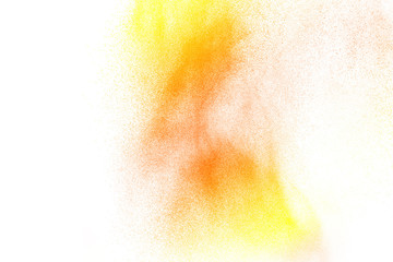 Abstract yellow orange powder explosion on white background. Freeze motion of yellow orange dust particles splash.