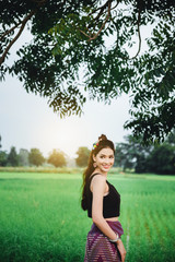 Beautiful Asian woman in local dress standing and enjoy natural on bamboo bridge in rice field