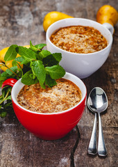 Apple crumble in two cups on wooden rustic background. Close up