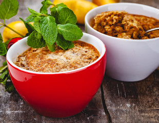 Apple crumble in two cups on wooden rustic background. Close up