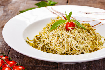 Italian pasta spaghetti with homemade pesto sauce on white plate. Close up