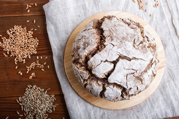 Yeast free homemade bread with whole rye and wheat grains on rustic wooden background.