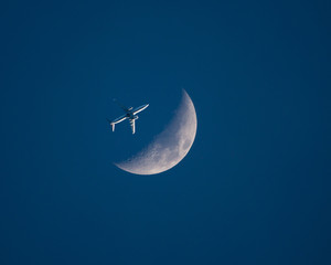Obraz na płótnie Canvas Airliner and Crescent Moon