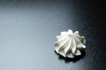 meringue meringue protein dessert in a white plate on a black background decorated with mint