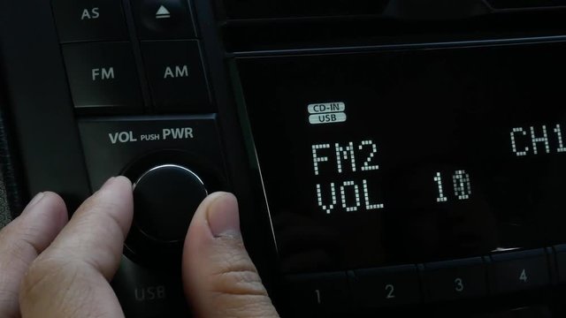 Close Up Of Asian Young Woman Turning On Radio  And  Adjust Music Sound Volume In Car. Auto Audio Concept