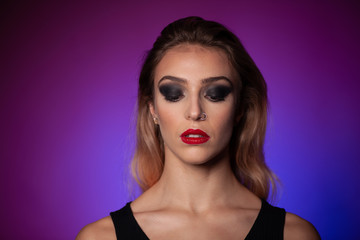 Beauty portrait of young blond caucasian woman over purple background