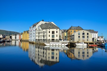 Naklejka na ściany i meble Stunning water reflection of the Art Nouveau architecture over a water canal of Alesund, Norway.
