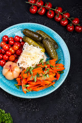 Different types of pickled vegetables on a dark background