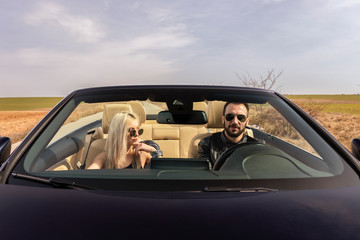 beautiful young couple traveling in a convertible