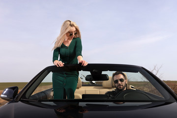 beautiful young couple traveling in a convertible
