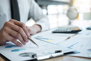 Businessman accountant working analyzing and calculating expense financial annual financial report balance sheet statement, doing finance making notes on report