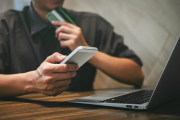 Fototapeta premium Businessman holding credit card and typing on laptop for online shopping and payment makes a purchase on the Internet, Online payment, Business financial and technology