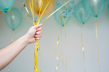 balloons blue and gold color in man's hand