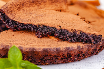 Sliced chocolate pie with cinnamon on wooden rustic table. Close up