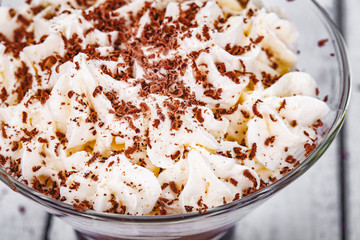 Homemade chocolate mousse in portion glass on wooden background. Close up
