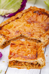 Homemade cabbage pie on wooden rustic background. Close up