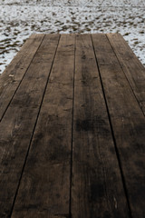 Empty wooden table with snow bokeh for a catering or food picnic texture