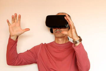 Close-up of a man in a pink T-shirt with glasses of virtual reality.