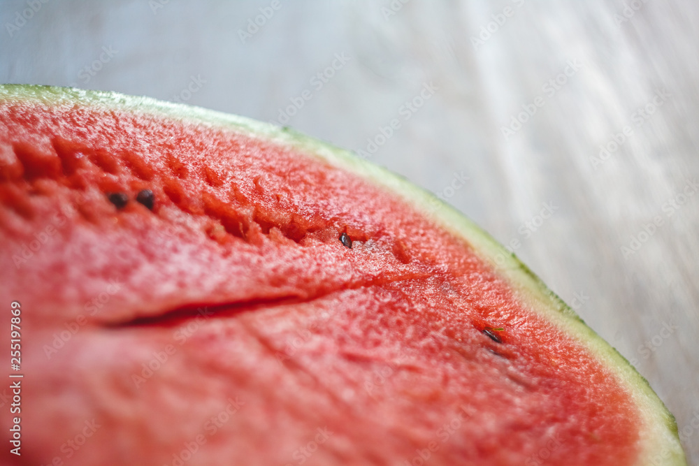 Sticker half a juicy watermelon on a light white wooden background, close-up. view from above