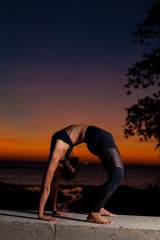Posture woman  silhouette practicing yoga with sunset background