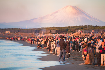 people on the beach with mountain at background