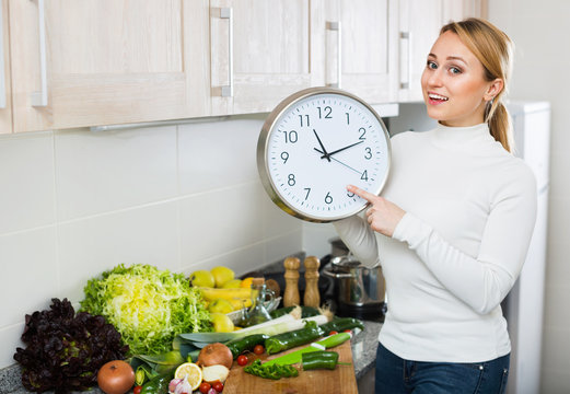Portrait of positive woman holding clocks