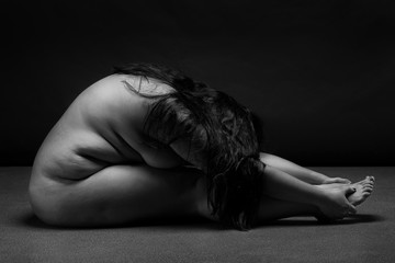 Obese nude woman doing yoga exercise. Morning Workout. Sport concept.