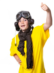 Young boy with yellow T-shirt, aviator goggles, plane and world ball smiling